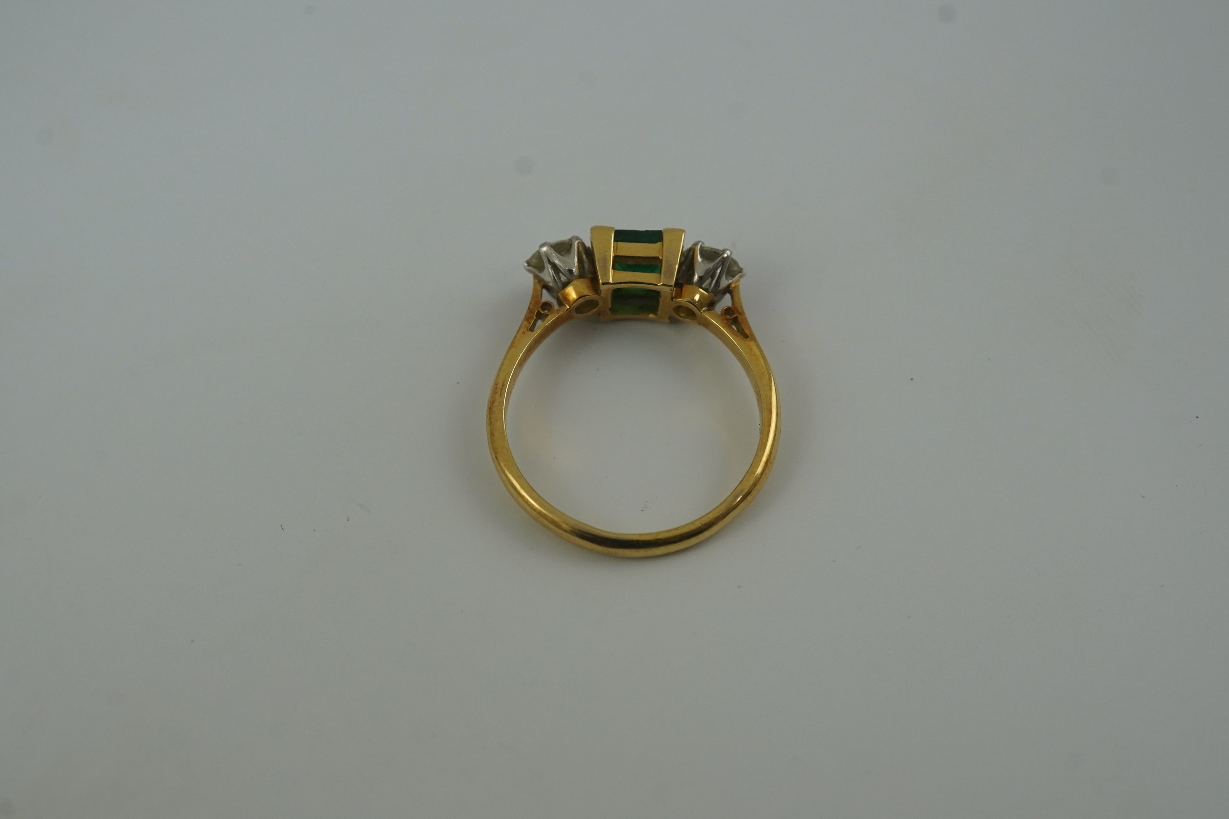 A mid 20th century 18ct gold and platinum, single stone emerald and two stone diamond set ring